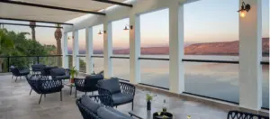 מרפסת המלון הפתוחה עם כורסאות ונוף פנורמי לכנרת